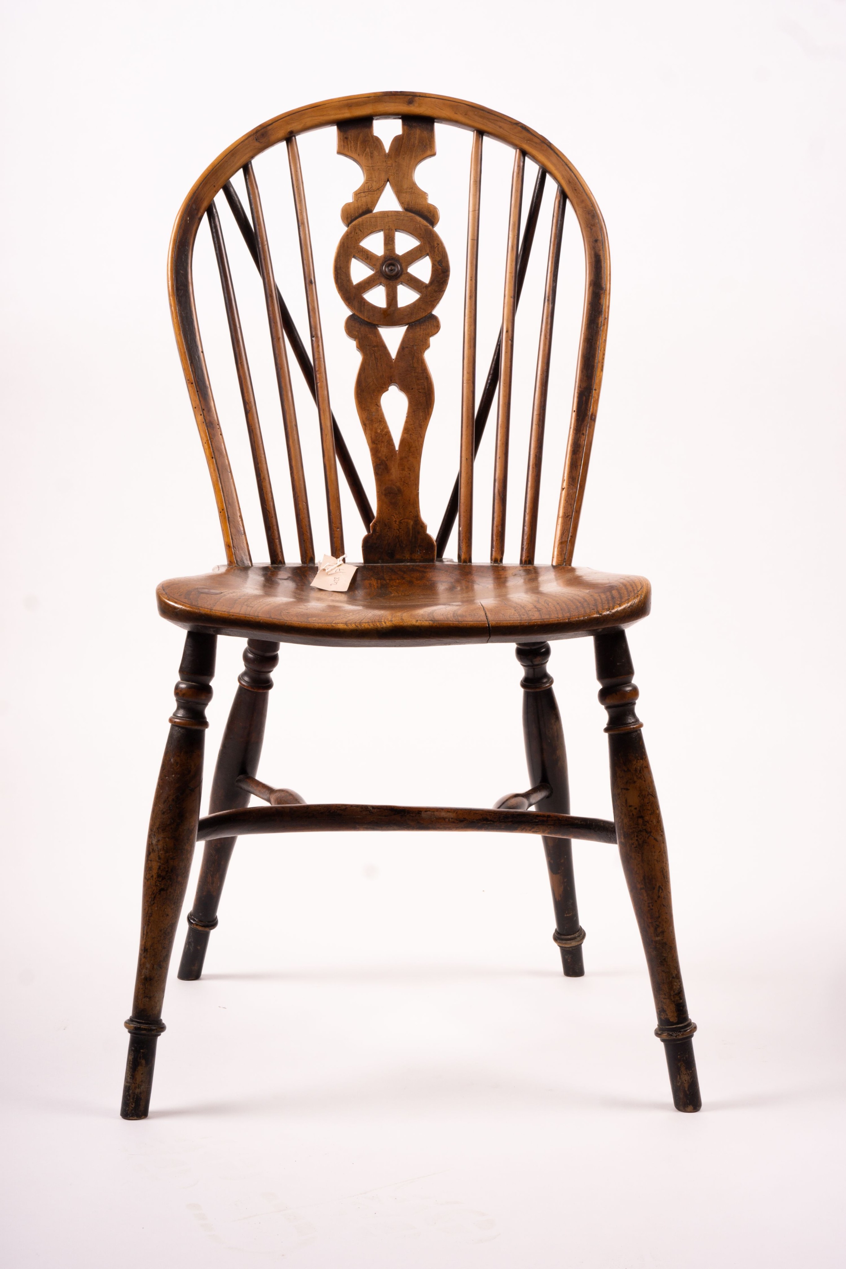 A mid 19th century ash and elm Derbyshire area Windsor elbow chair, together with a 19th century yew and elm Windsor wheel back chair with crinoline stretcher